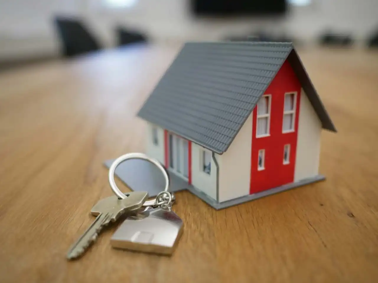 Maquette de maison posée près d’un trousseau de clés, évoquant le financement de travaux